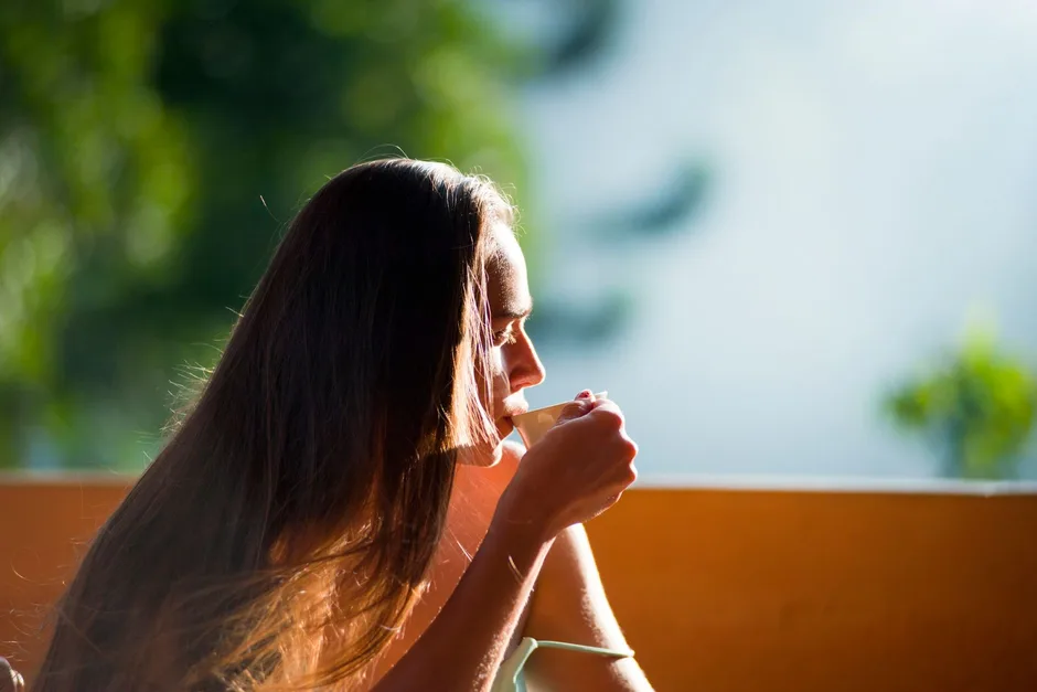A person holding a warm cup of tea in the morning, thinking