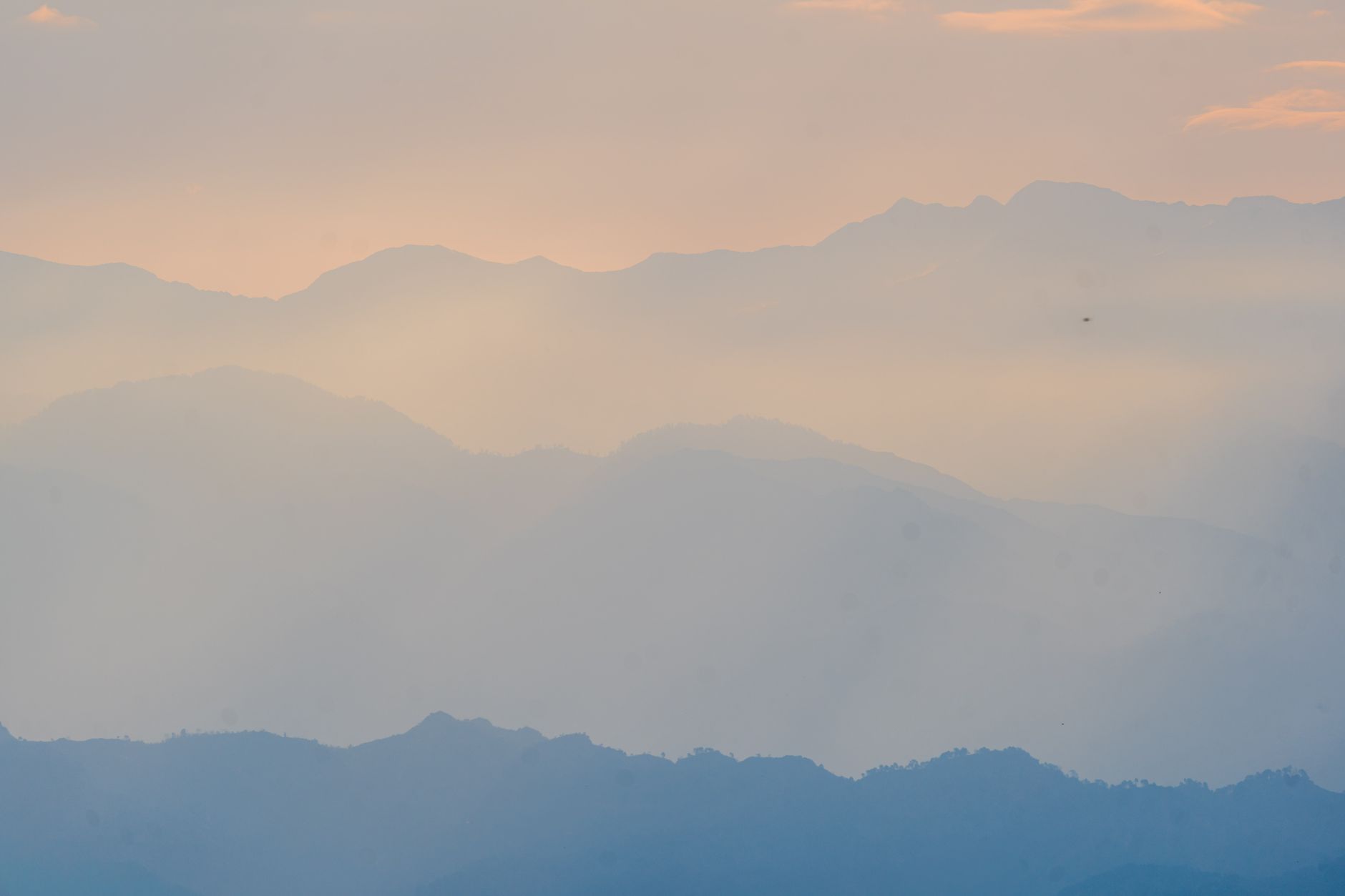 Misty mountains at sunrise in soft pastel layers